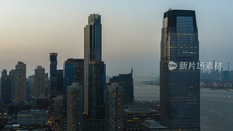 黄昏时分，泽西城的保卢斯·胡克(Paulus Hook)从哈德逊河眺望远处曼哈顿哈德逊广场的剪影。